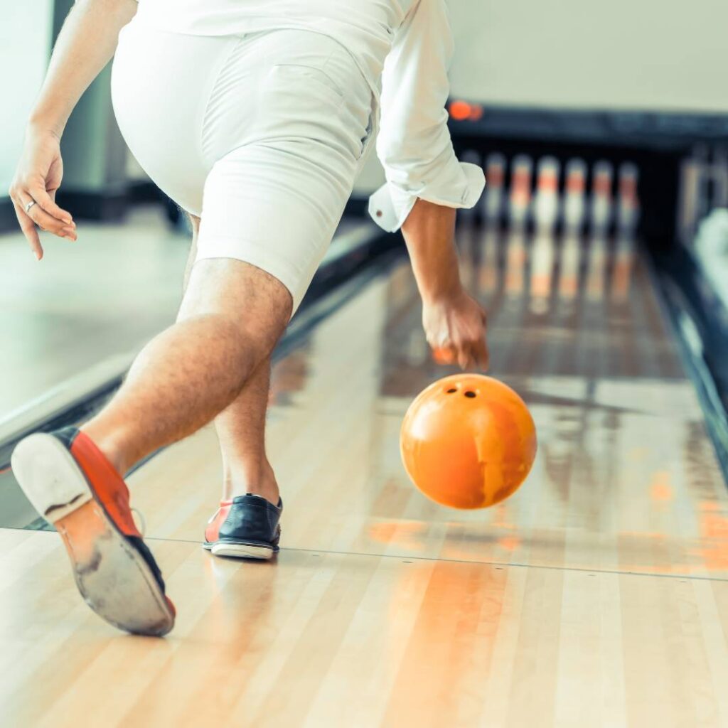 Man throwing a bowling call down the lane at a fundraising love a bowl event