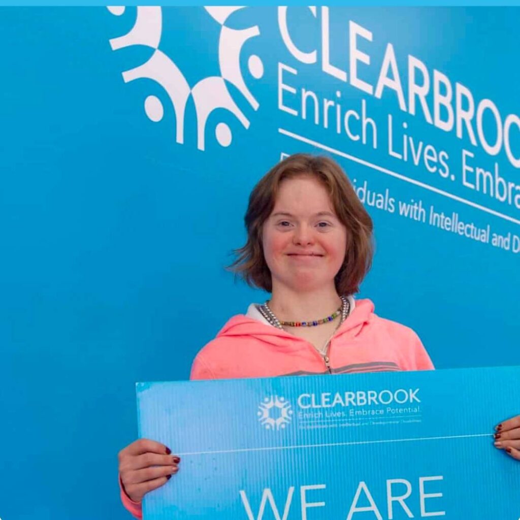 Clearbrook family member proudly displaying a we are family sign