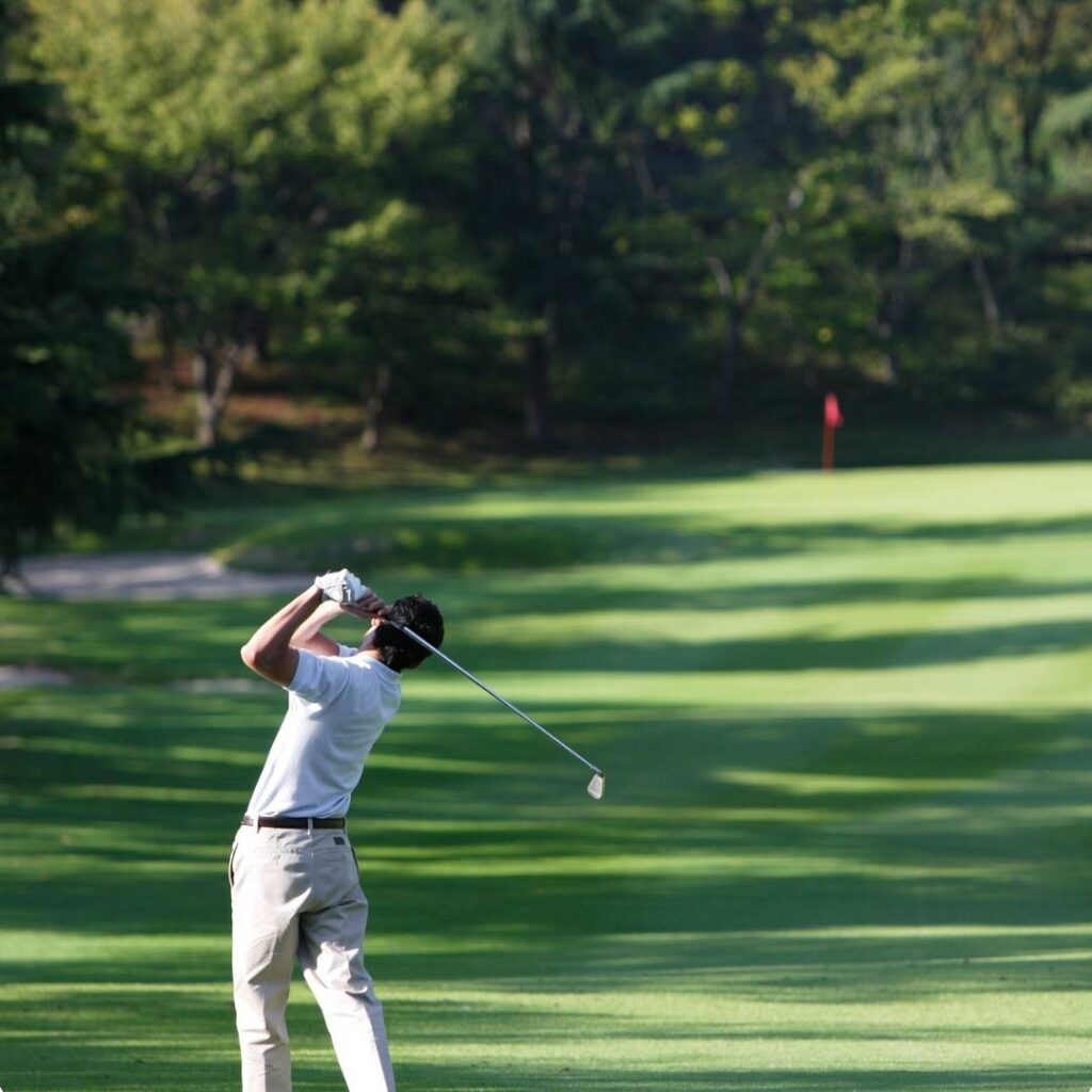Golfer swinging his club during a beautiful day of golf